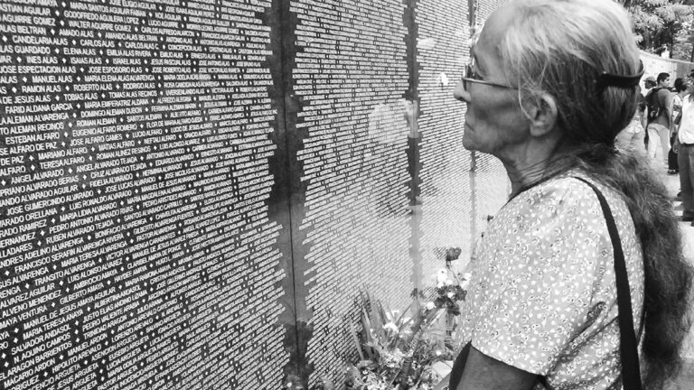 Mujer mirando el Monumento a la Memoria y la Verdad, en el Parque Cuscatlán (San Salvador), donde se encuentran los nombres de las víctimas de las masacres durante el conflicto armado. Crédito: MUPI.