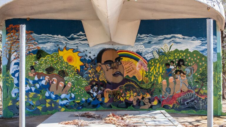 Vista general y detalles de la pintura mural que, junto con la placa y la estructura de una paloma, integran la edificación en memoria de las víctimas de esta masacre. Crédito: Espacio de Memorias y Derechos Humanos de El Salvador.